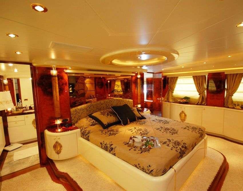 a bedroom with a bed and a chandelier aboard CROCUS Yacht for Charter