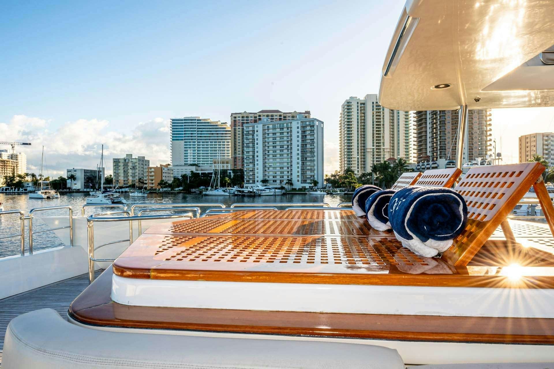a pair of sunglasses on a deck overlooking a city aboard VIVERE Yacht for Charter