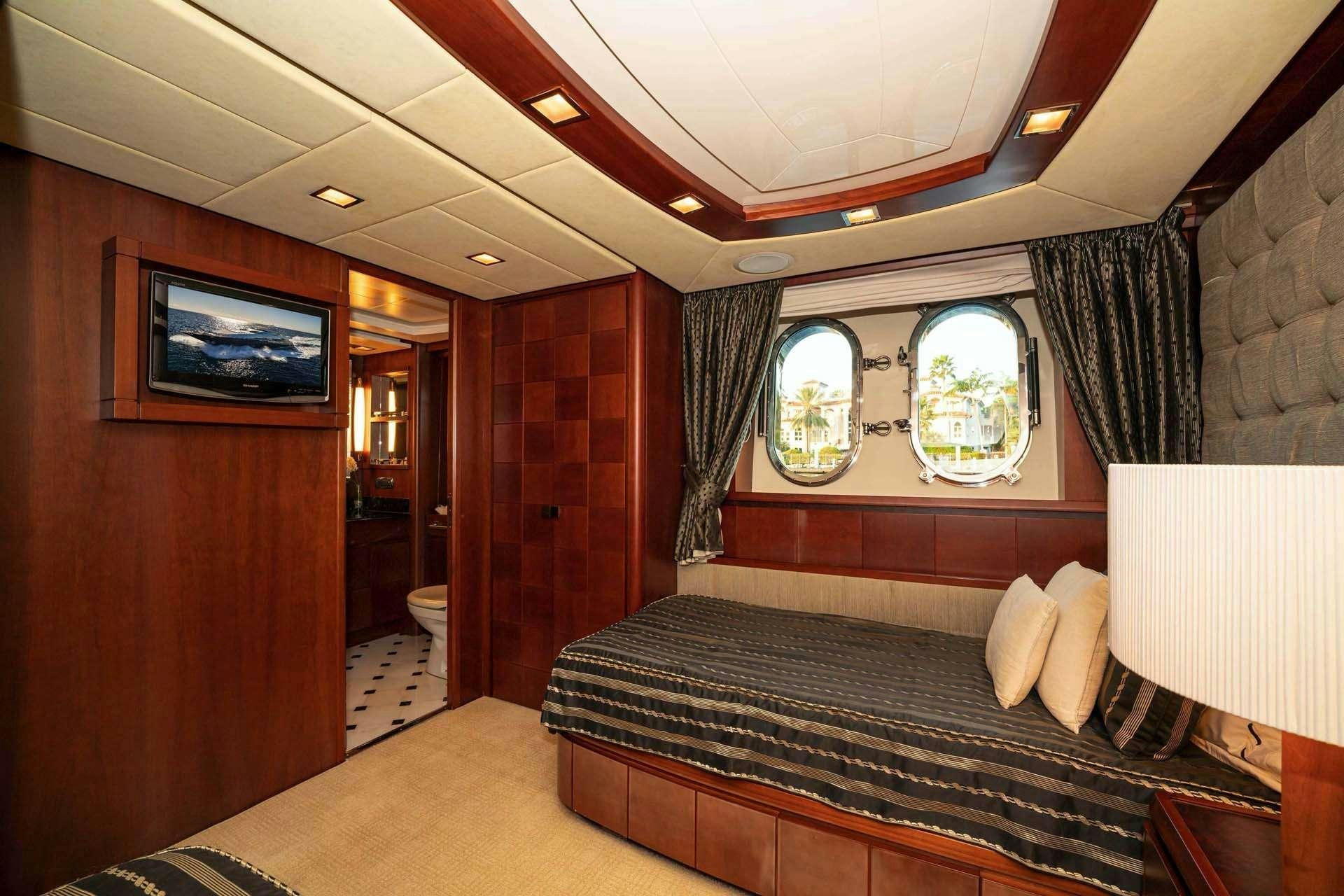 a room with a bed and a tv aboard VIVERE Yacht for Charter
