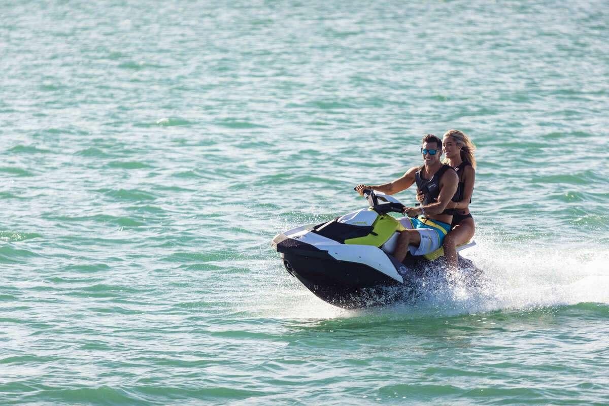 a man and woman riding a jet ski in the water aboard INCEPTION Yacht for Charter