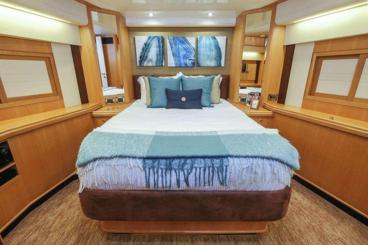 a bed with blue sheets aboard SILVER LINING Yacht for Charter