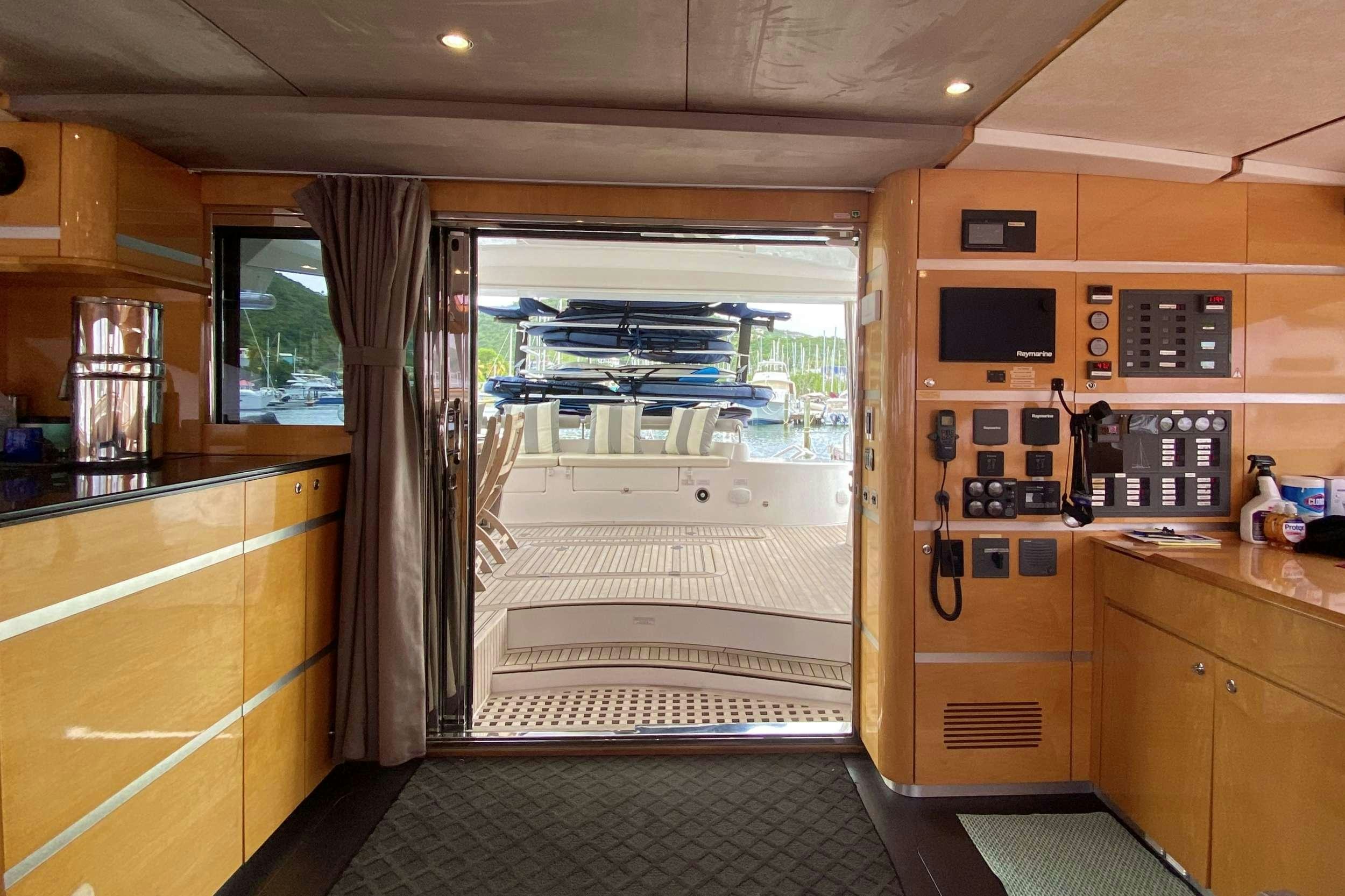 a room with a glass door and a deck with a view of the water and the outside aboard TRES SUENOS Yacht for Charter