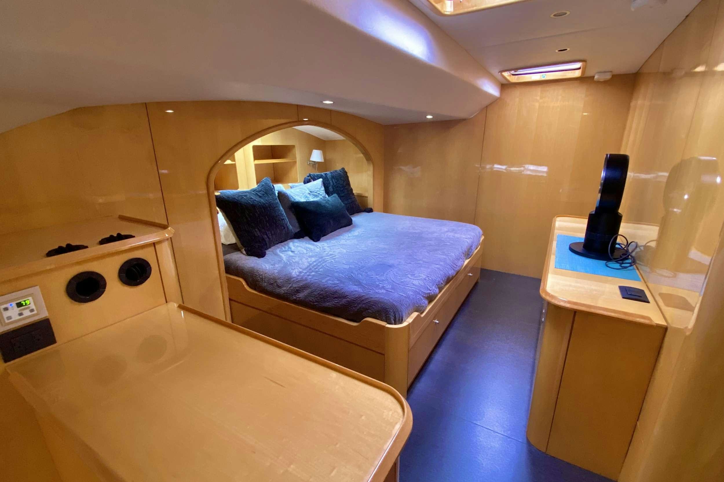 a room with a bed and a desk aboard TRES SUENOS Yacht for Charter