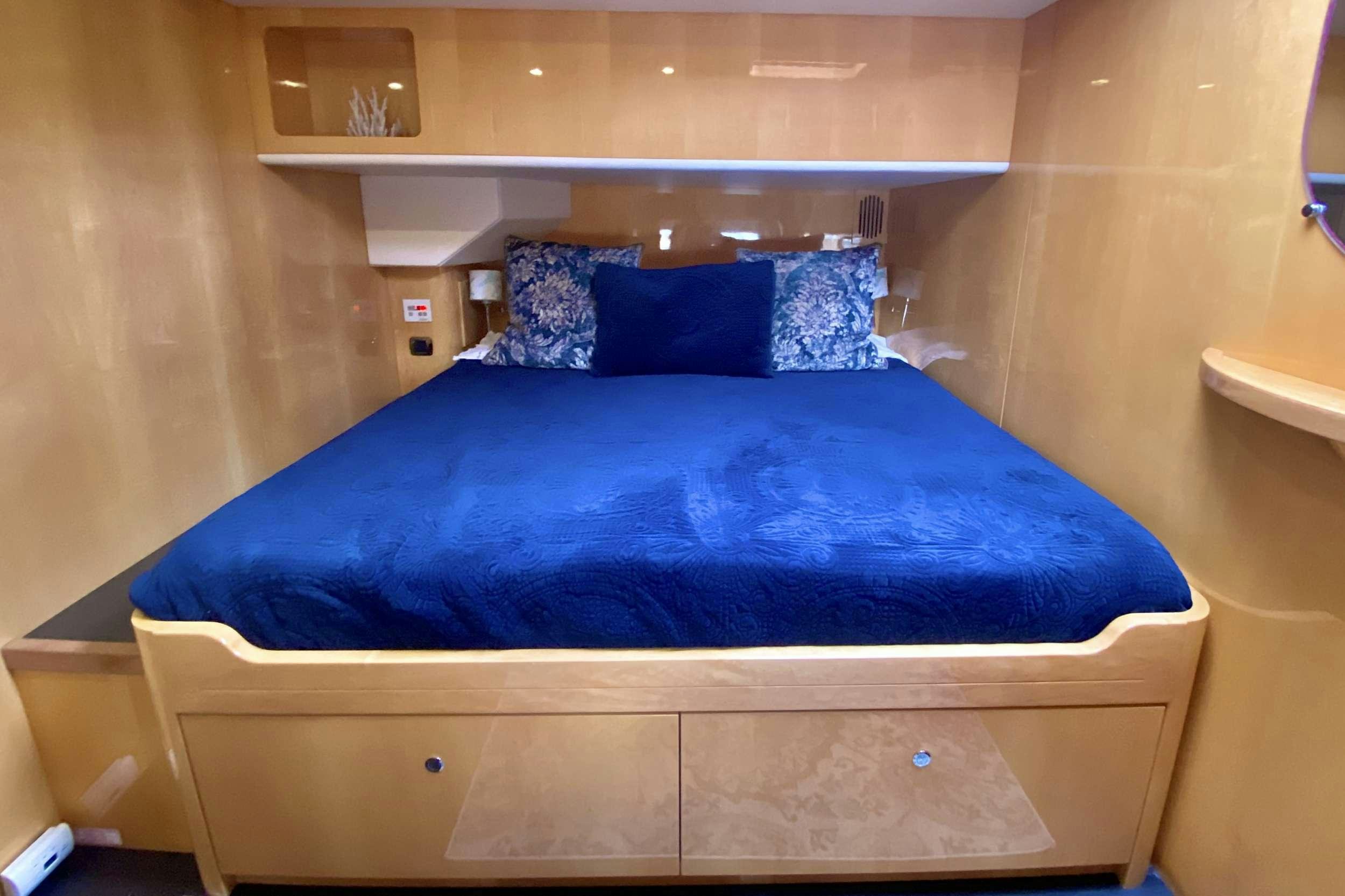 a bed with blue sheets aboard TRES SUENOS Yacht for Charter