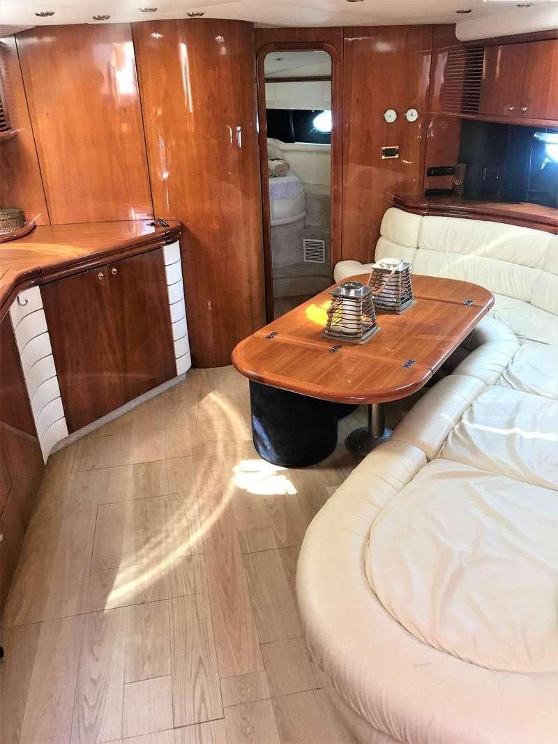 a room with a table and couch aboard OBSESSION Yacht for Charter