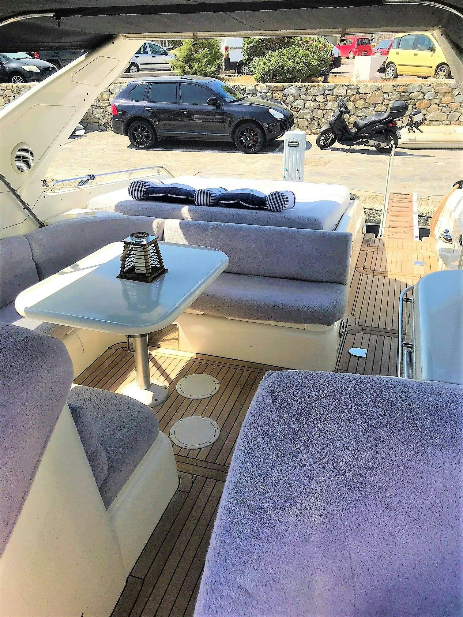 a couch and a table outside aboard OBSESSION Yacht for Charter
