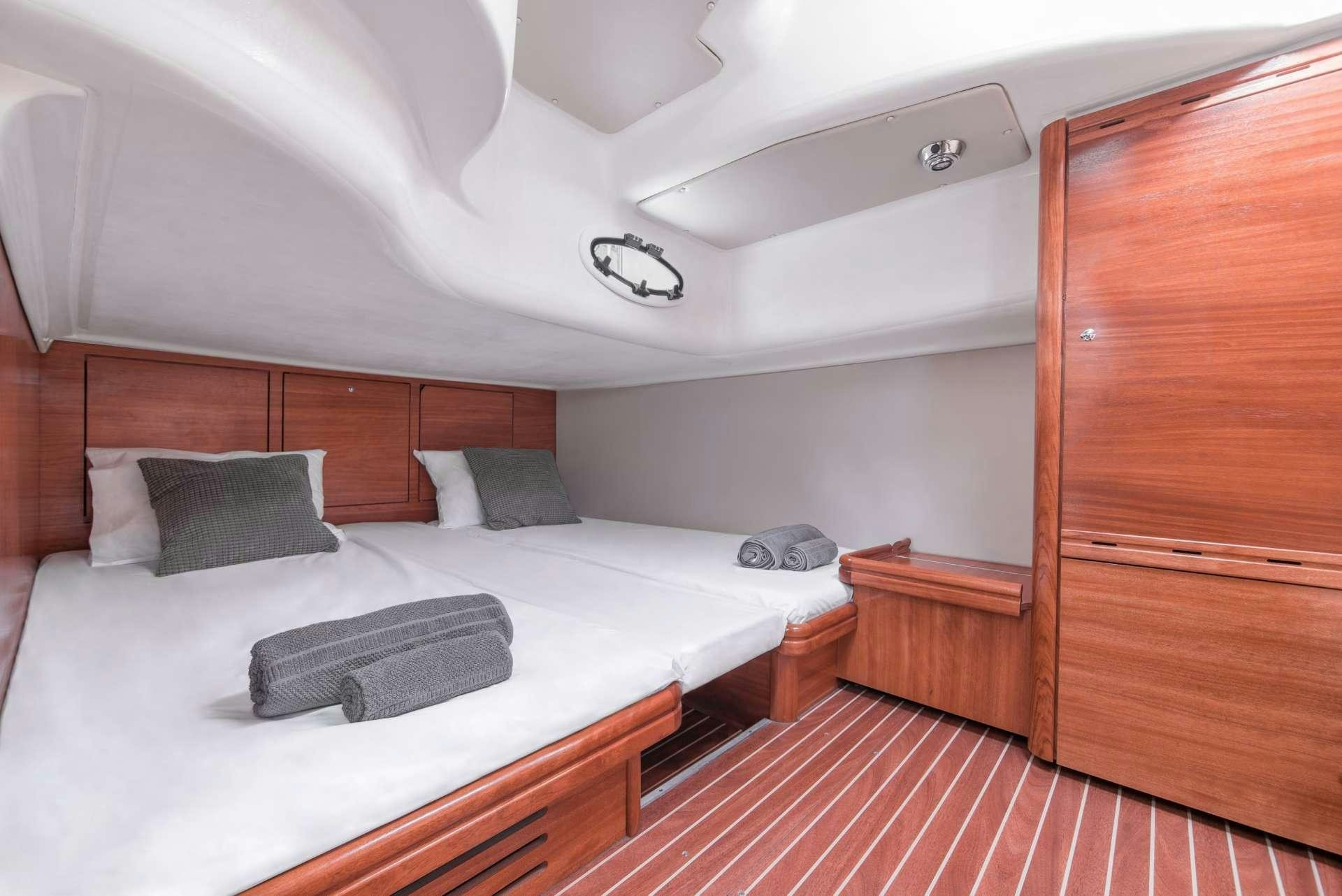 a bed with a white sheet and a wooden headboard aboard AEGEAN BLUE Yacht for Charter