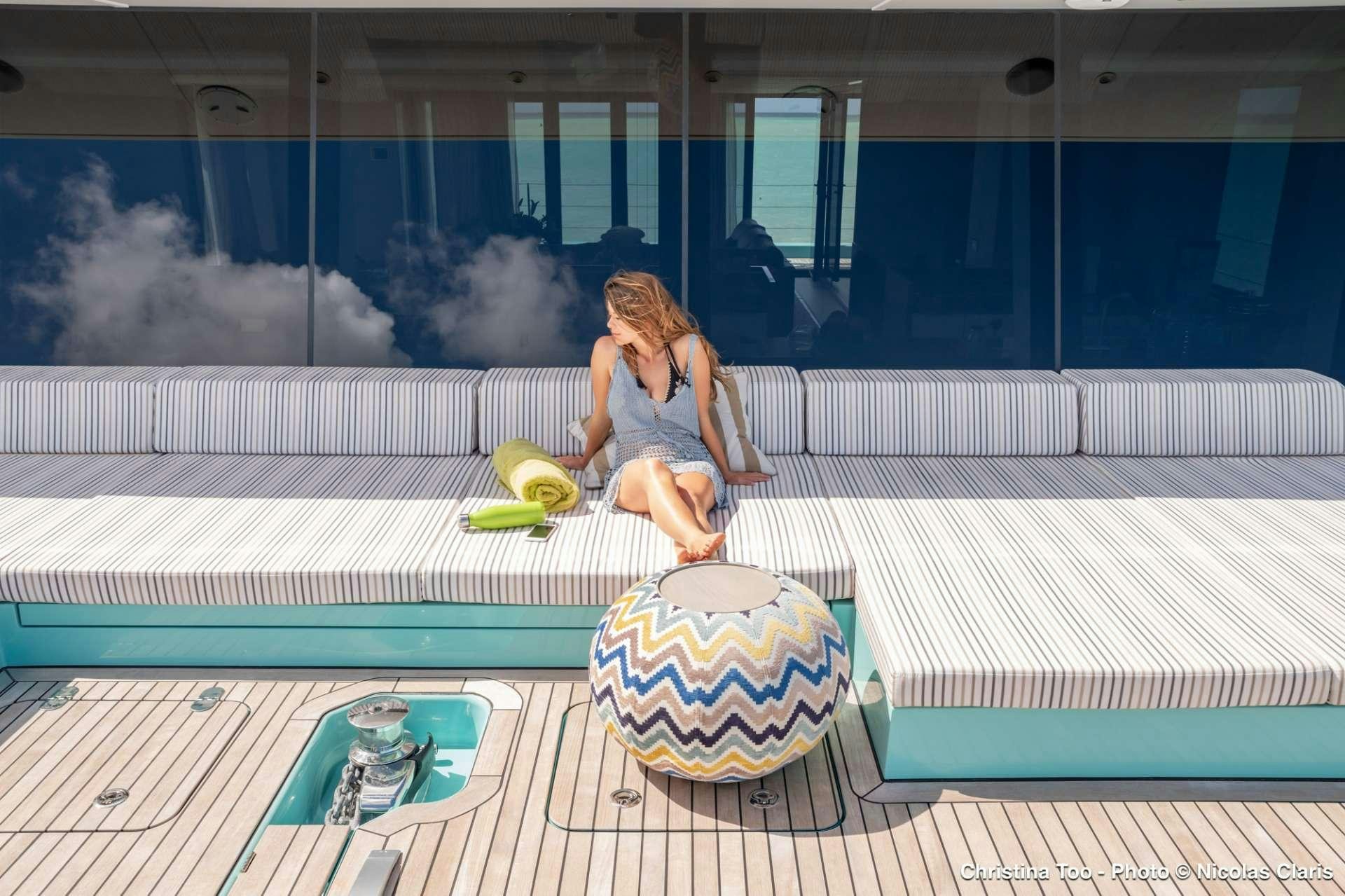 a woman sitting on a deck aboard CHRISTINA TOO Yacht for Charter