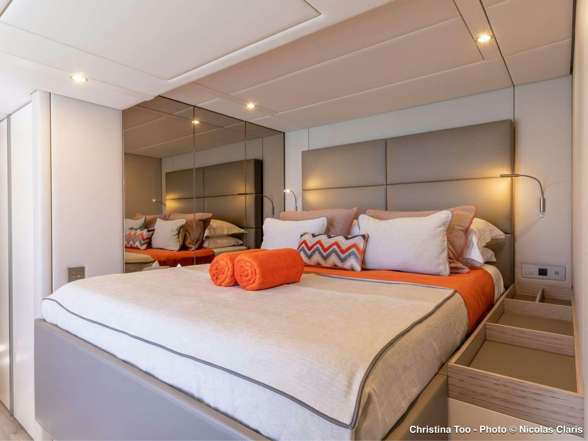 a bed with orange pillows aboard CHRISTINA TOO Yacht for Sale