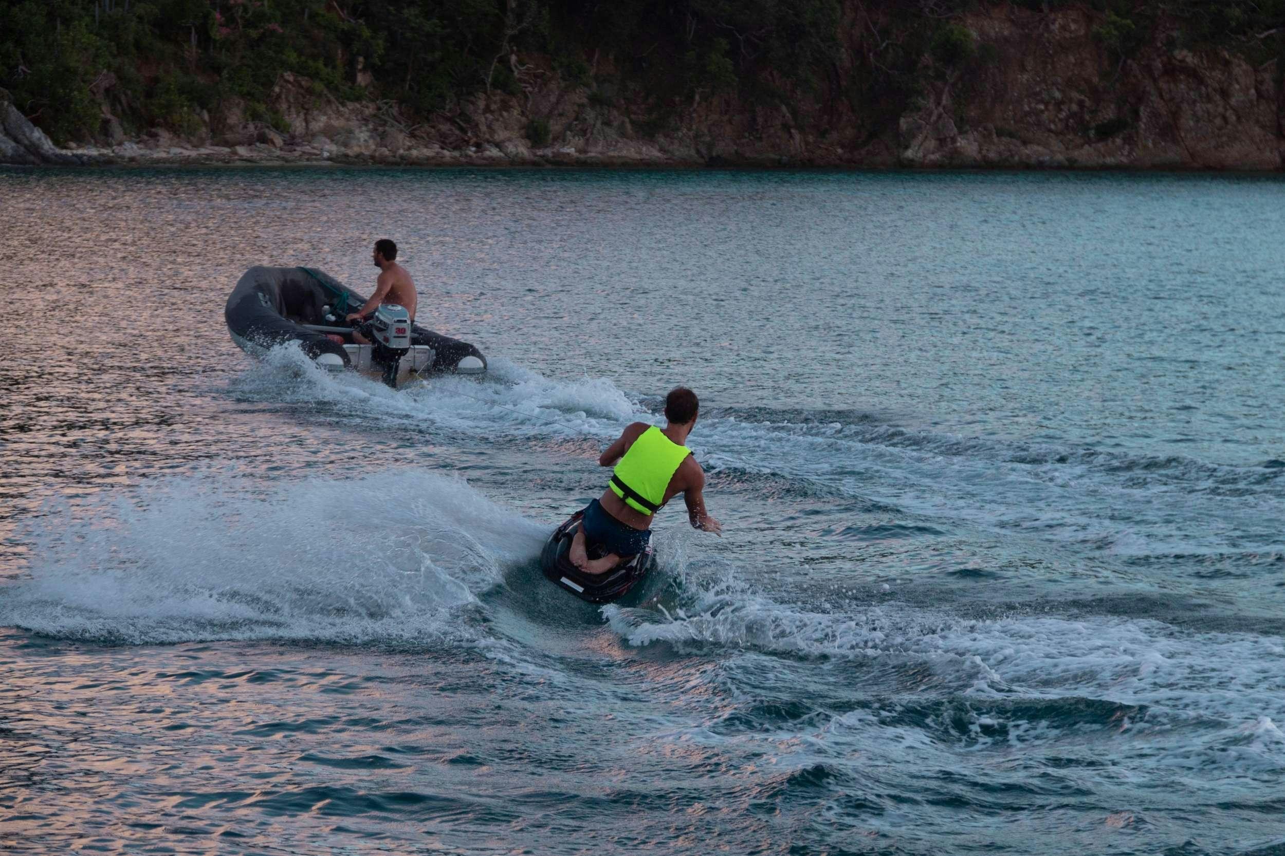 a group of people riding surfboards aboard NEMO Yacht for Charter