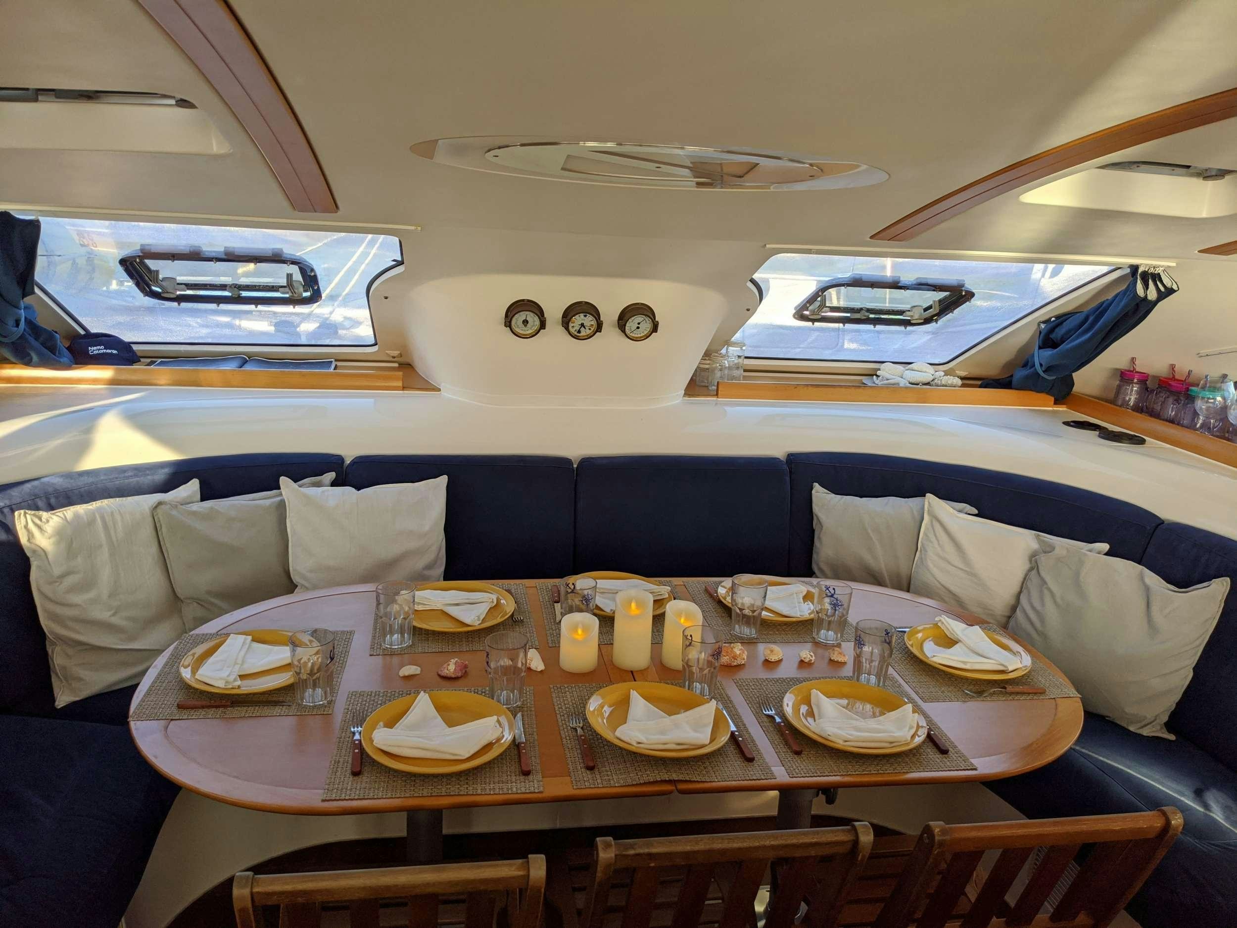 a dining table with plates and glasses aboard NEMO Yacht for Charter