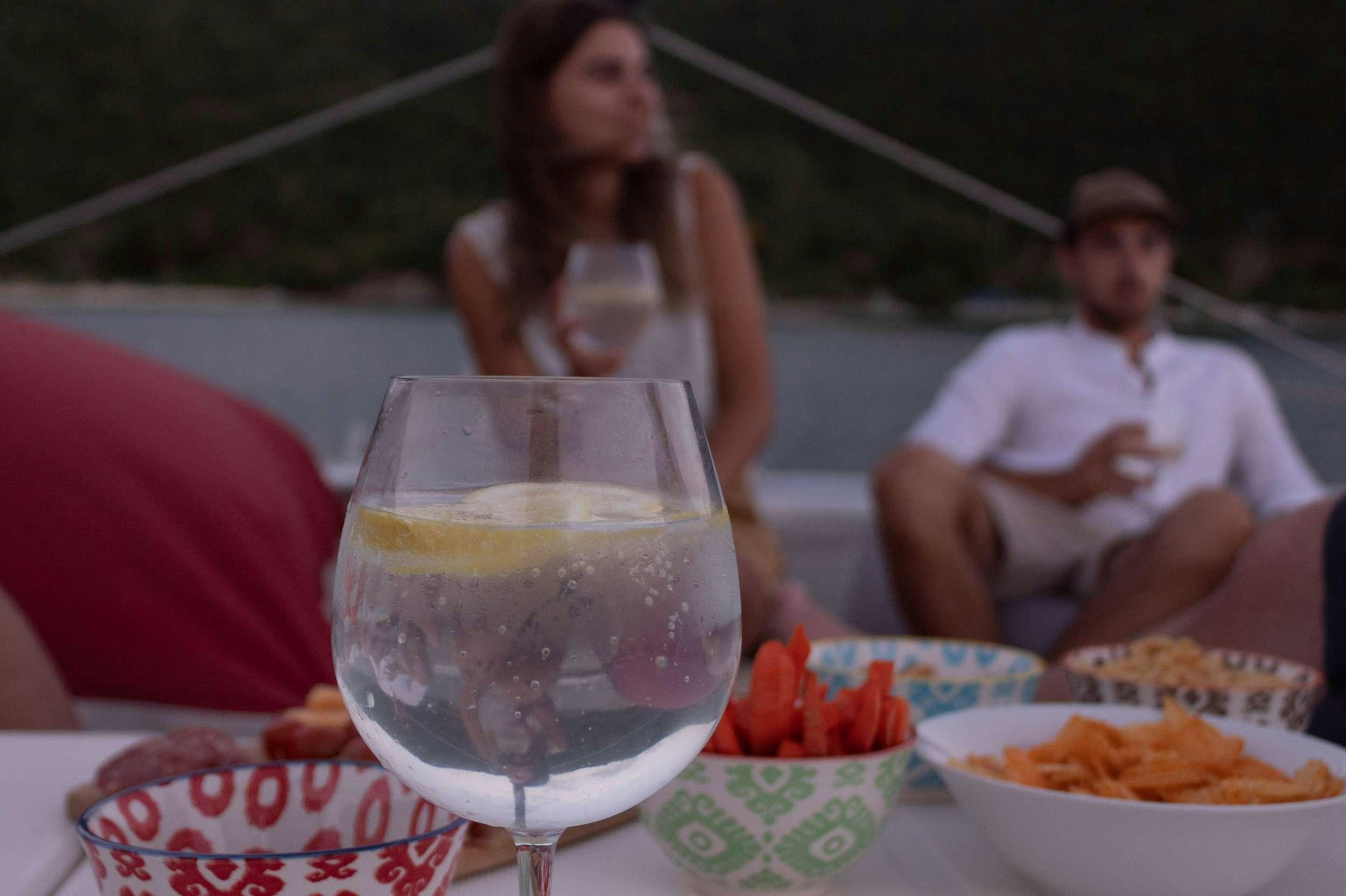 a person sitting at a table with a glass of wine and a plate of food aboard NEMO Yacht for Charter