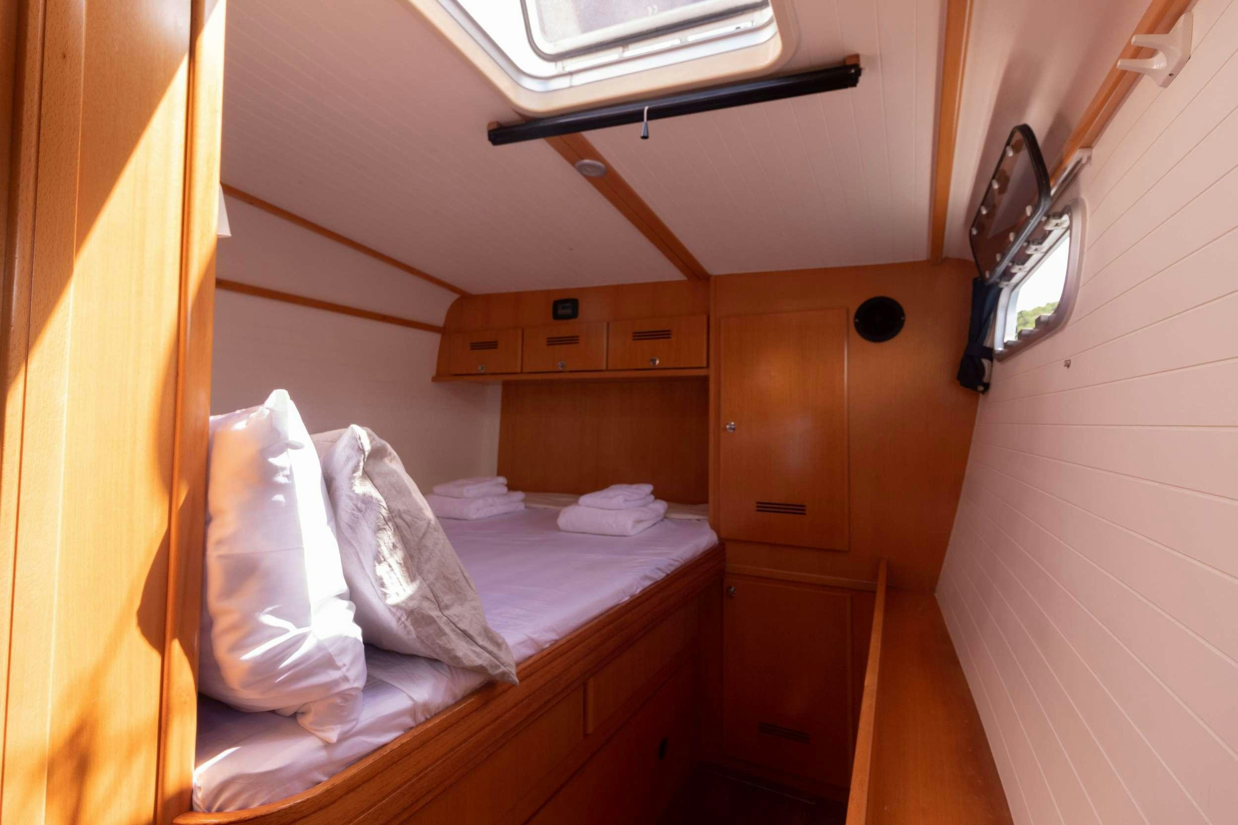 a room with a bed and a dresser aboard NEMO Yacht for Charter