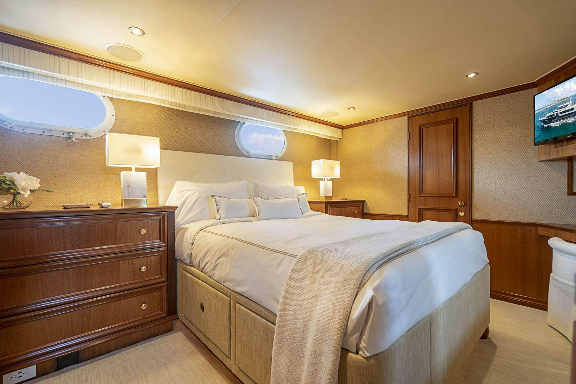 a hotel room with a bed and a television aboard TRUE NORTH Yacht for Charter