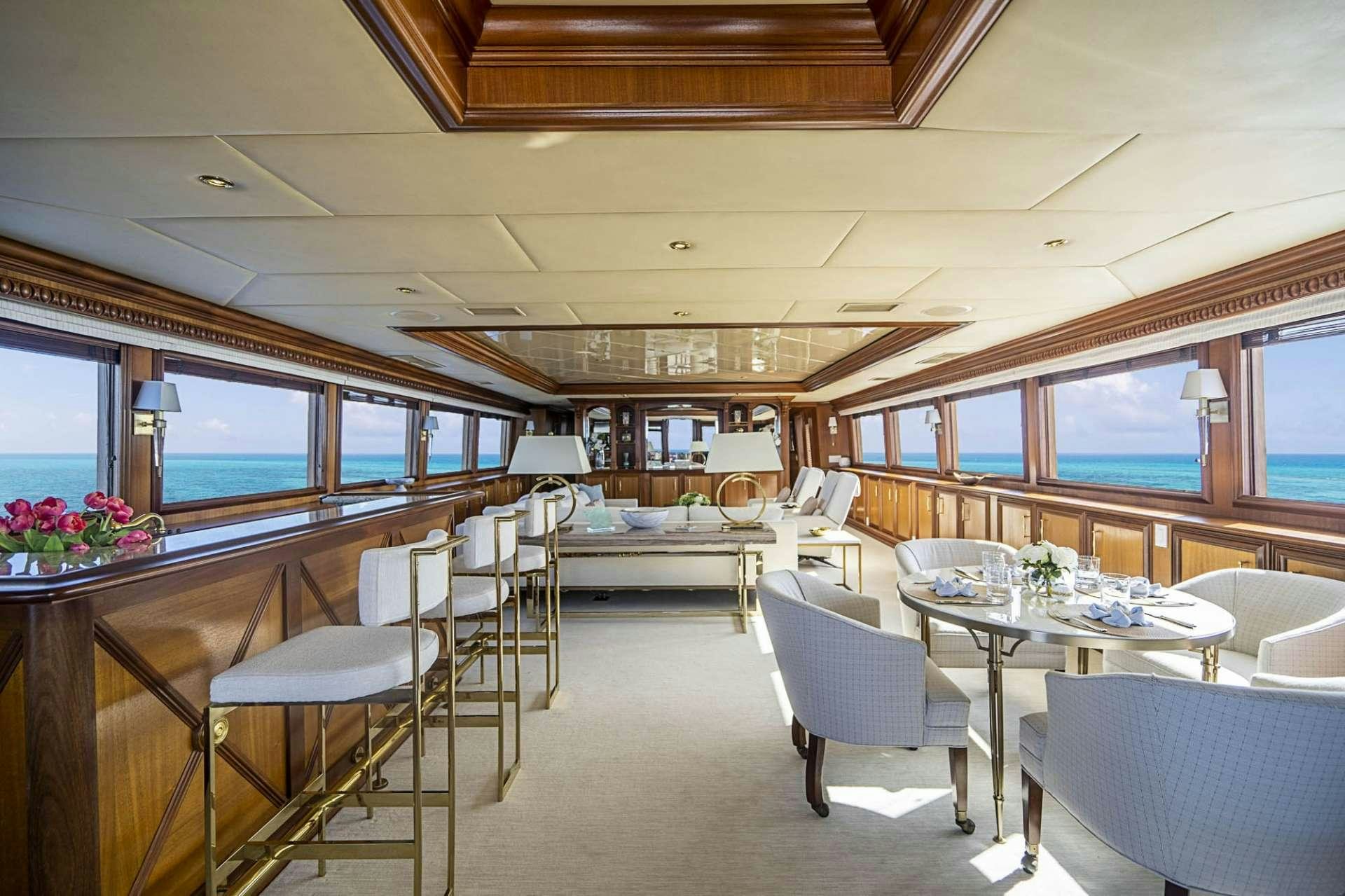 a room with tables and chairs aboard TRUE NORTH Yacht for Charter