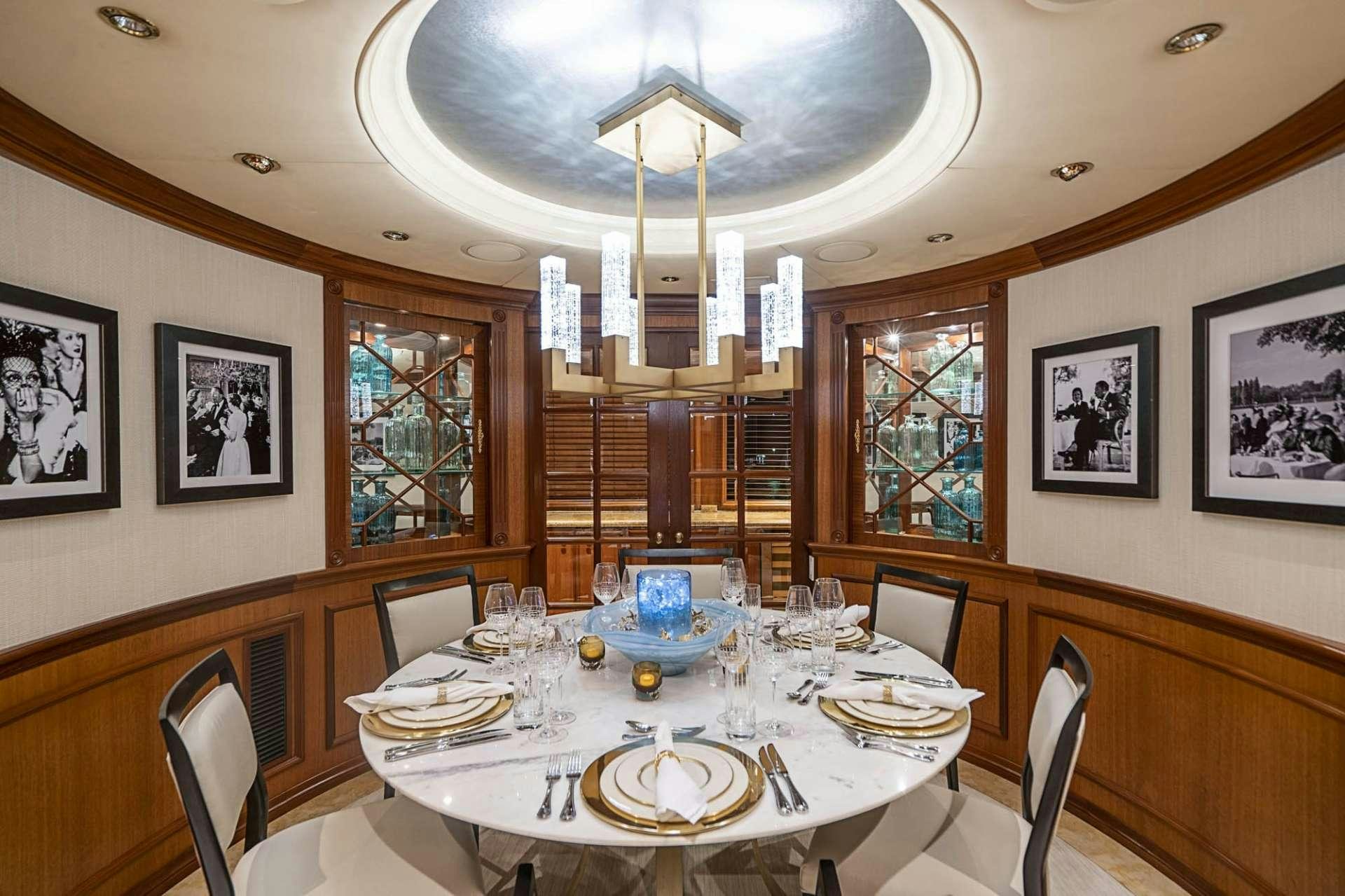 a dining room with a chandelier aboard TRUE NORTH Yacht for Charter