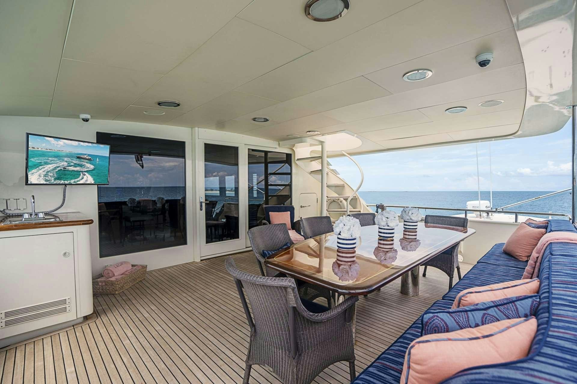 a living room with a large blue couch and a large window aboard TRUE NORTH Yacht for Charter