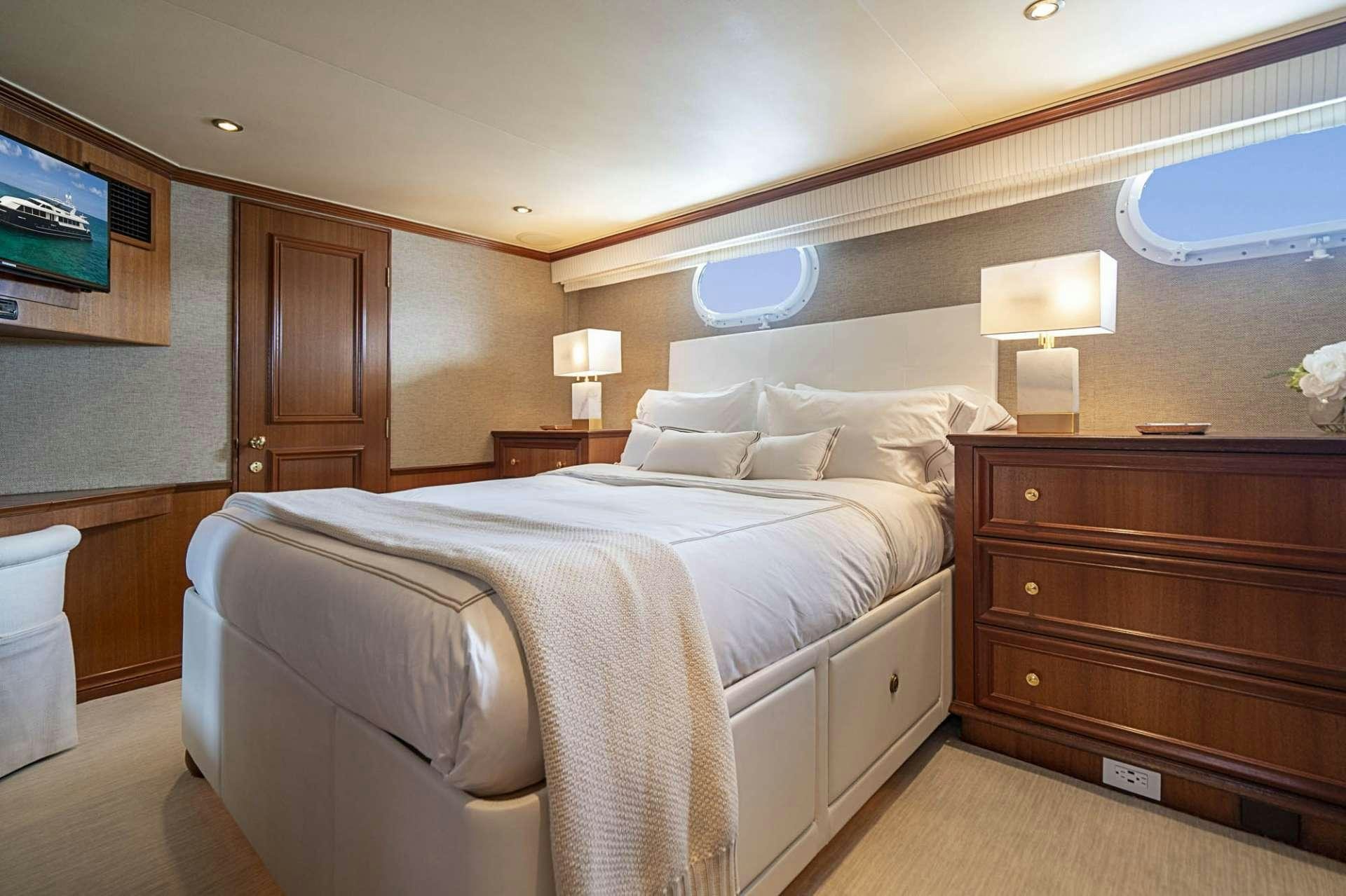 a bedroom with a bed and a dresser aboard TRUE NORTH Yacht for Charter