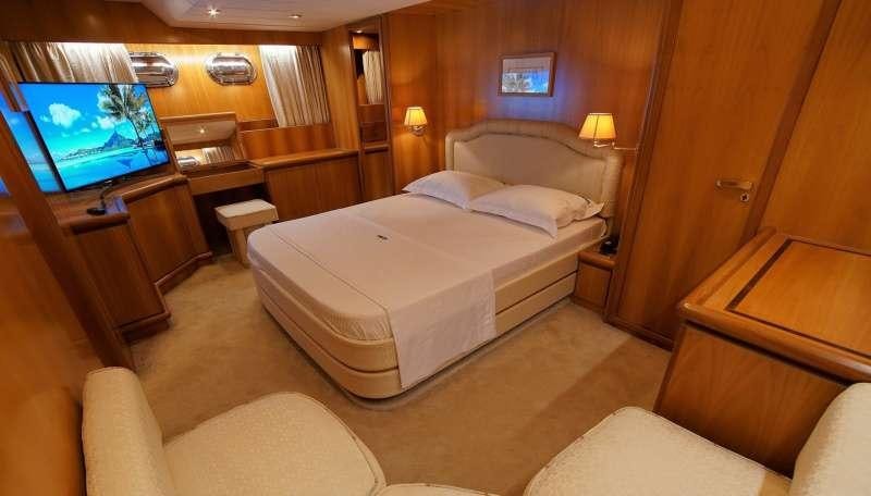 a hotel room with a bed and a television aboard EMILIA Yacht for Charter