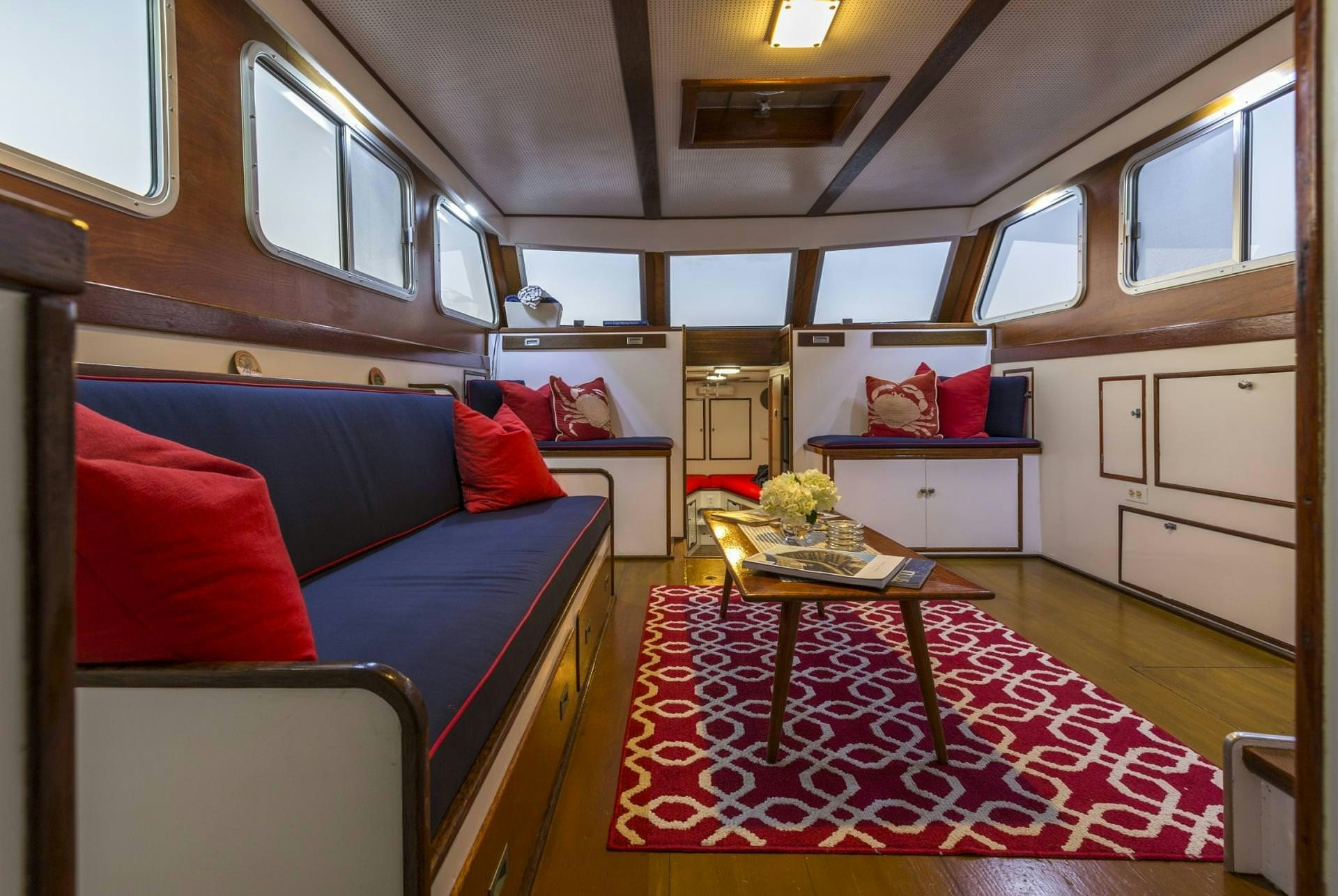 a train with a table and couch aboard KINGFISHER Yacht for Charter