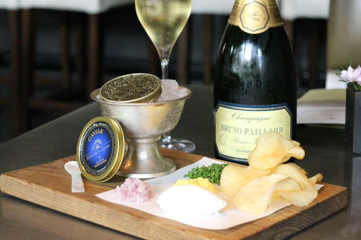 a bottle of wine next to a plate of chips and a glass of wine aboard KINGFISHER Yacht for Charter