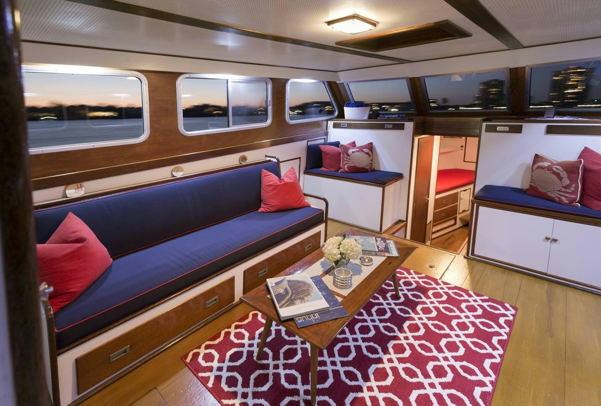 a train with a couch and a coffee table aboard KINGFISHER Yacht for Charter