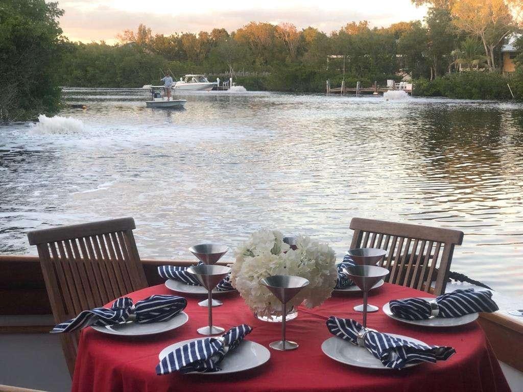 a table with glasses and plates on it by a lake aboard KINGFISHER Yacht for Charter