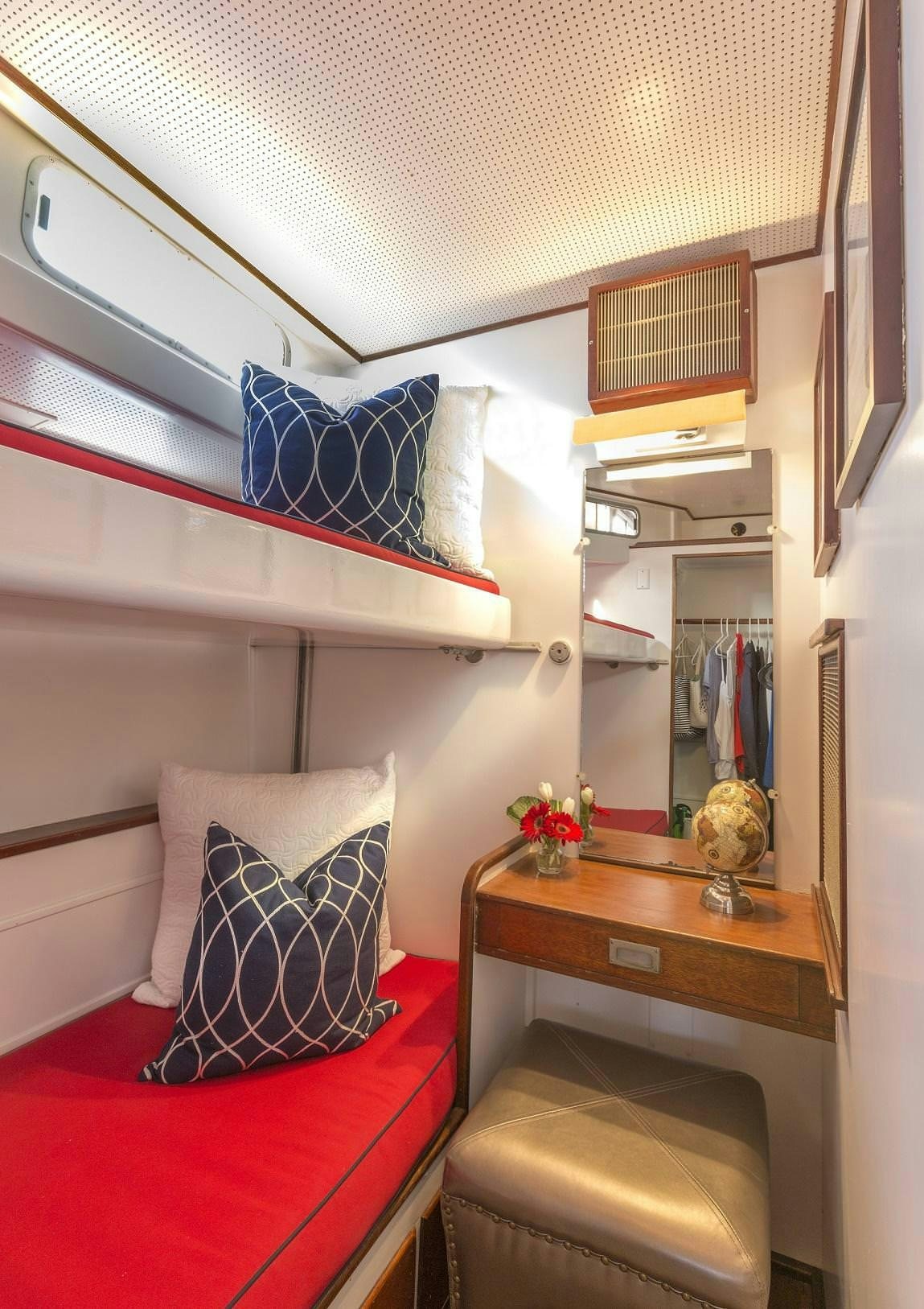 a room with a red couch and a mirror aboard KINGFISHER Yacht for Charter