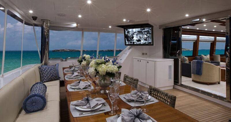 a large living room with a large glass table and chairs aboard RENAISSANCE Yacht for Charter