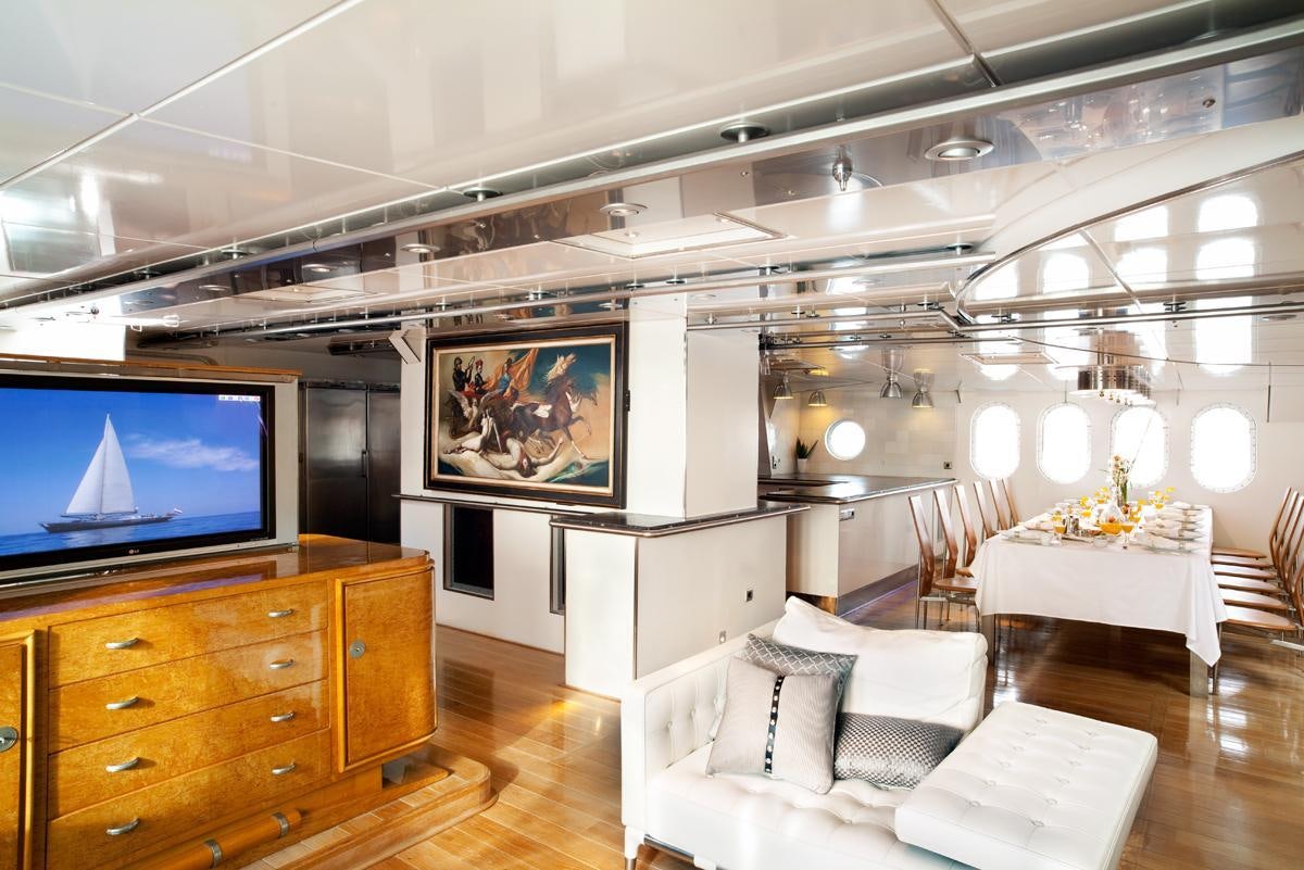 a room with a tv and a table aboard DWINGER Yacht for Charter