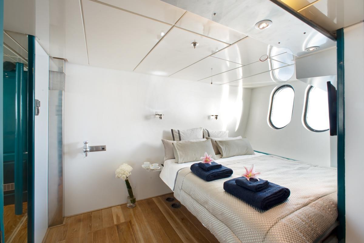 a room with a bed and a chair aboard DWINGER Yacht for Charter