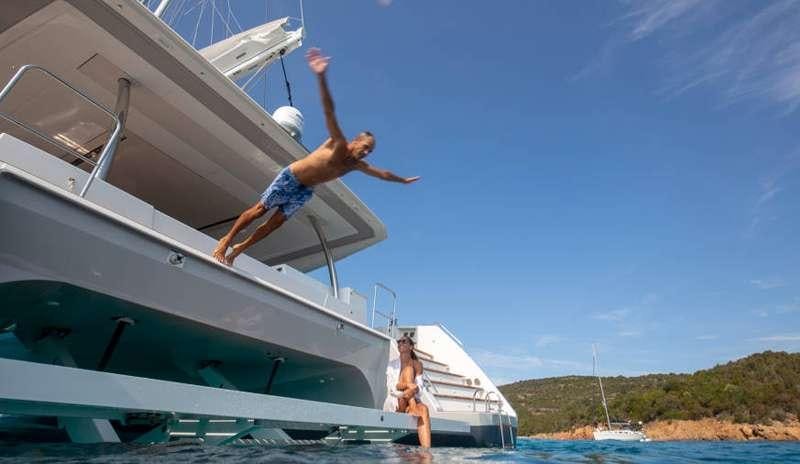 a man jumping off a boat aboard BLACK CAT Yacht for Charter