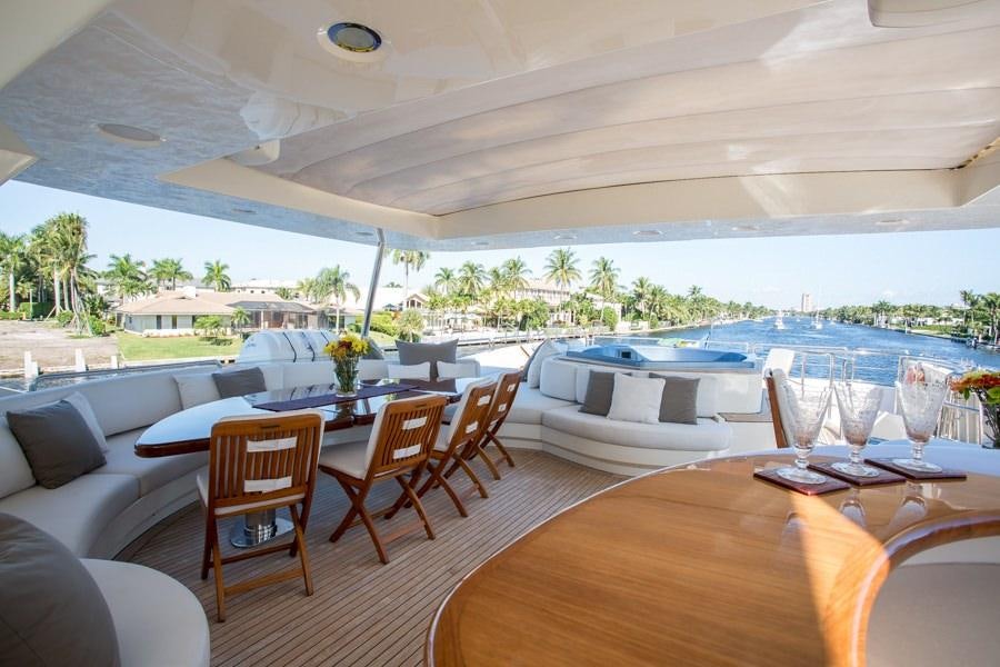 a large patio with a table and chairs and a pool aboard HAPPY HOUR Yacht for Charter