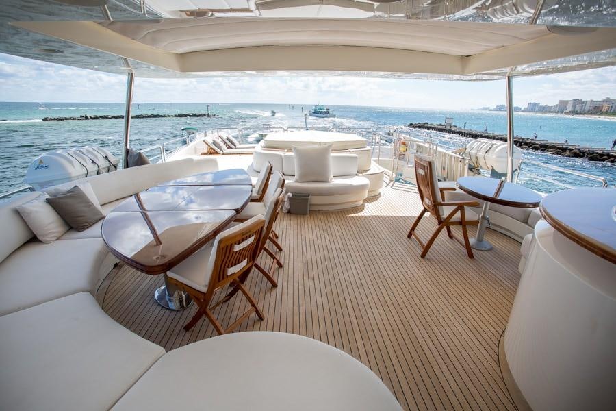 a room with a table chairs and a large body of water aboard HAPPY HOUR Yacht for Charter