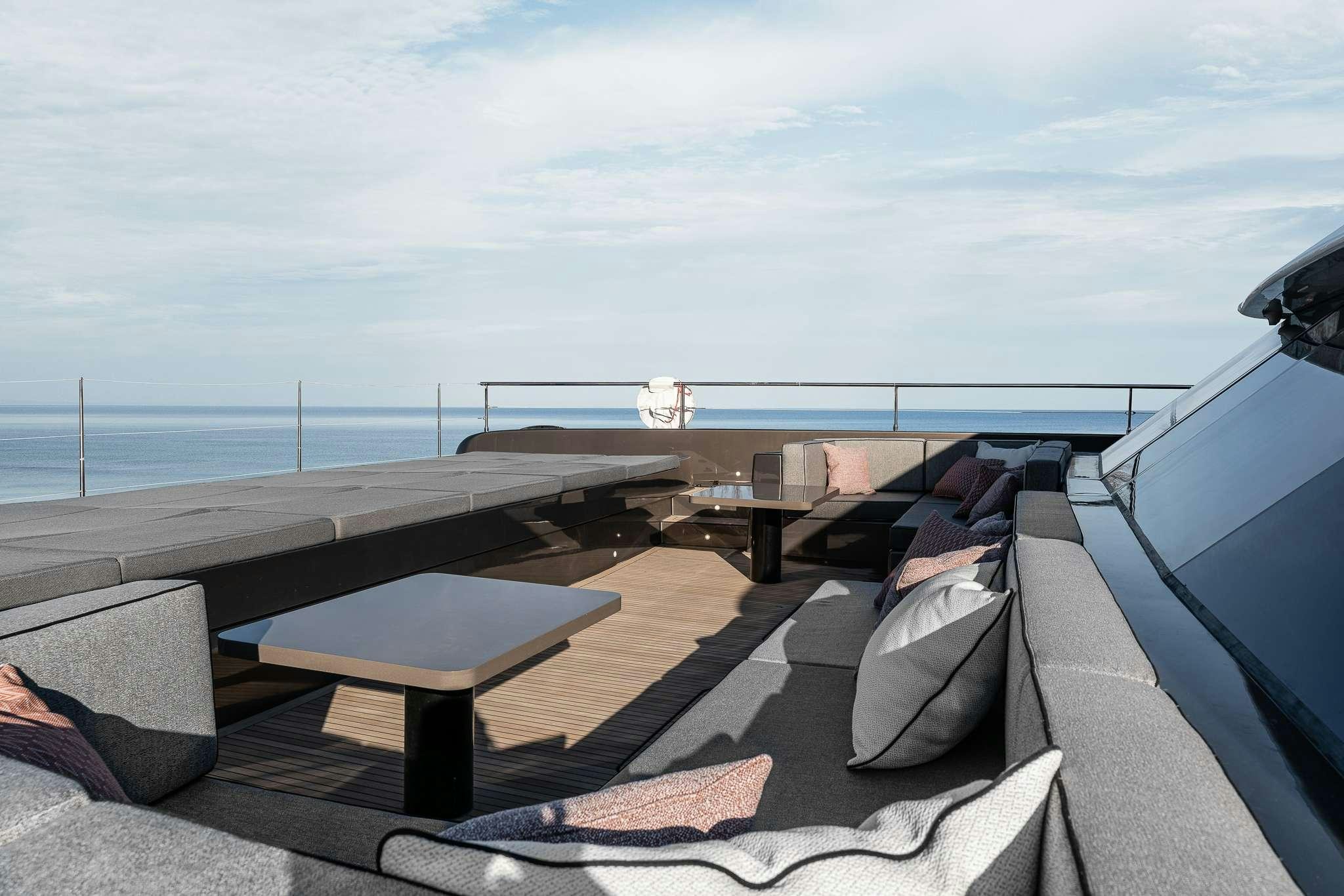 a deck with a view of the ocean and a large boat aboard SEIYA Yacht for Charter