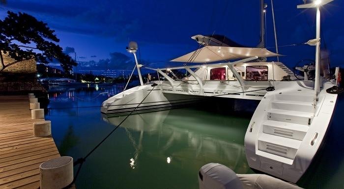 a white boat docked at a pier aboard MAGIC CAT Yacht for Charter