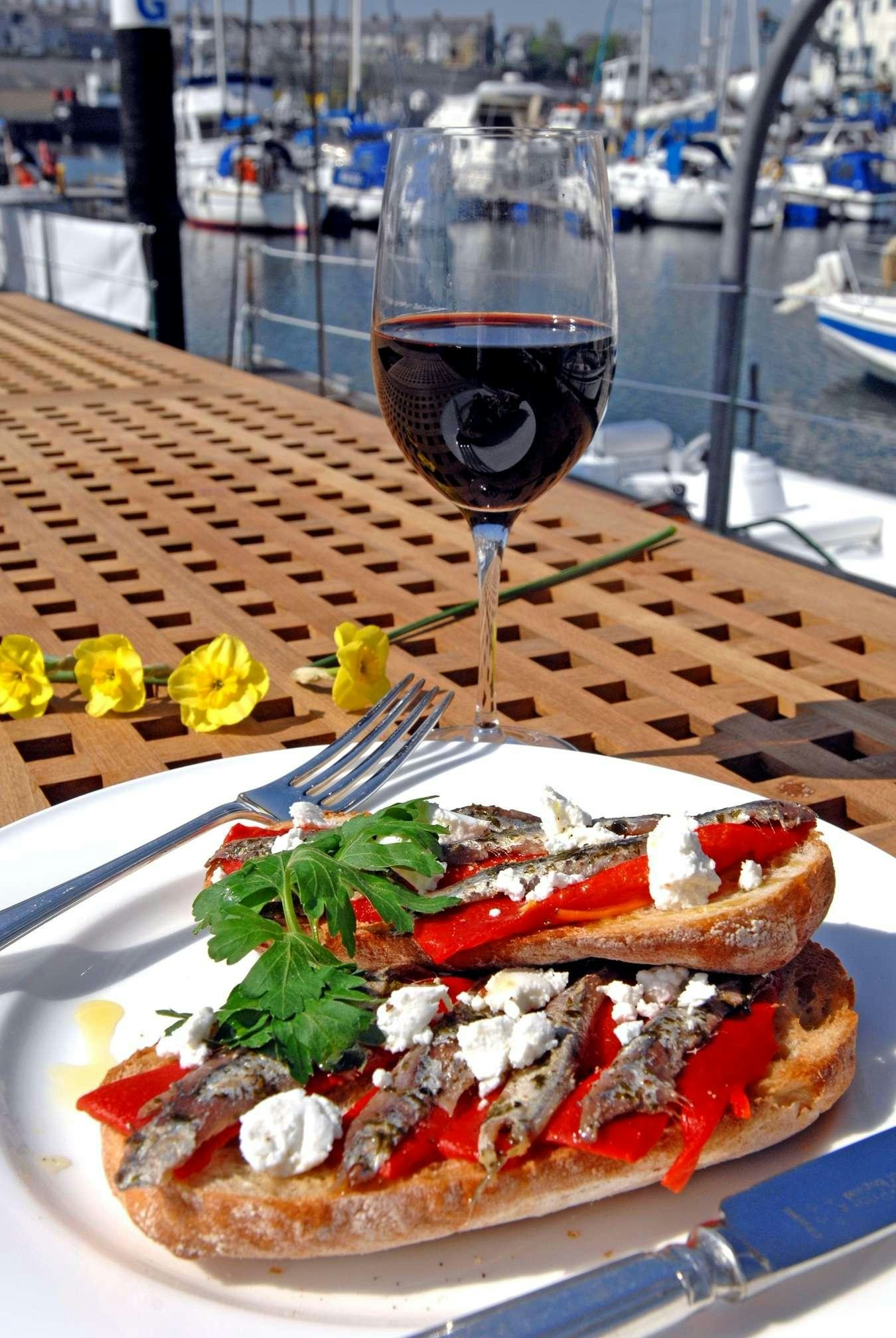 a plate of food and a glass of wine aboard Halcyon Yacht for Charter