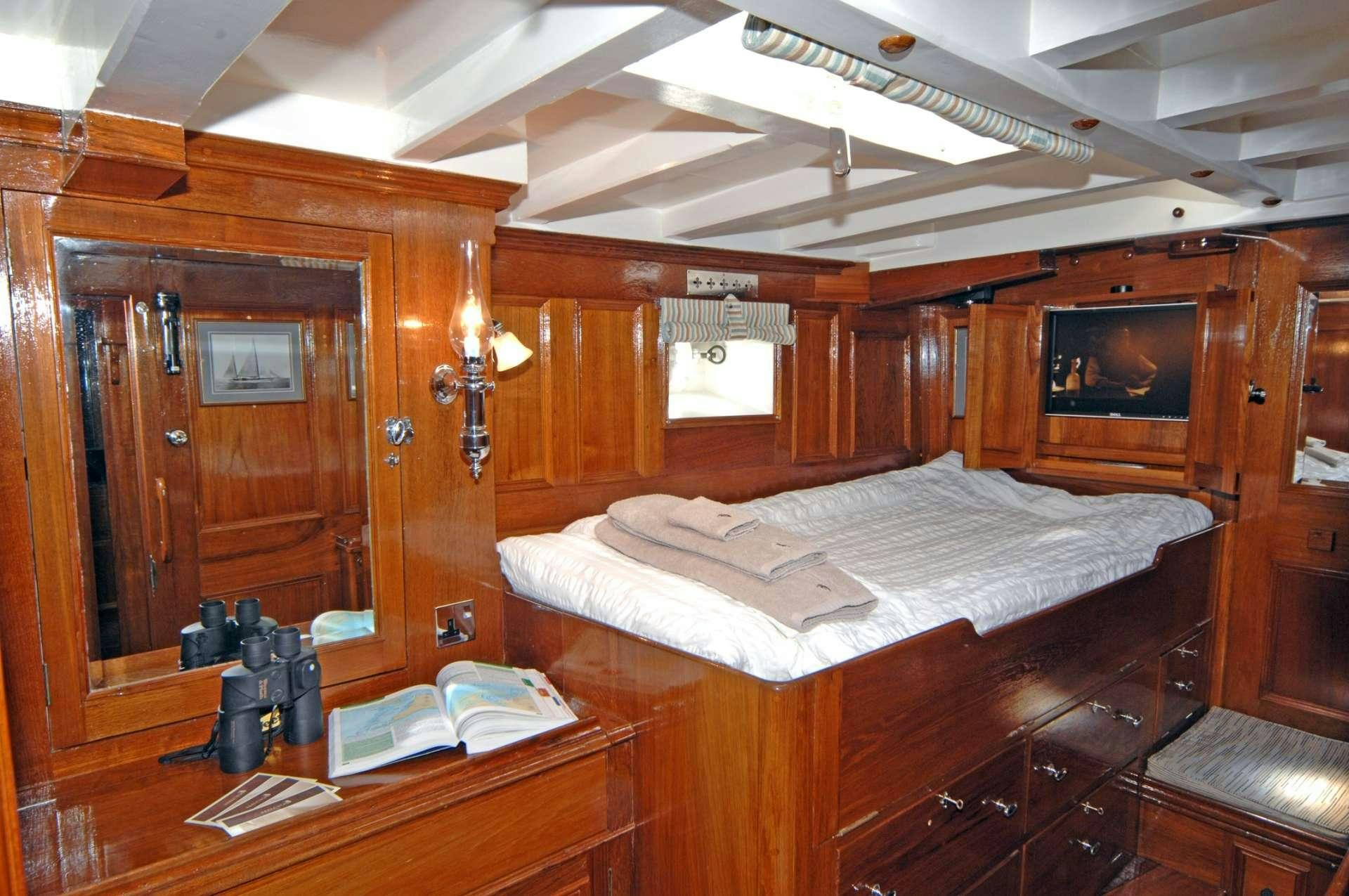 a room with a bed and a table aboard Halcyon Yacht for Charter