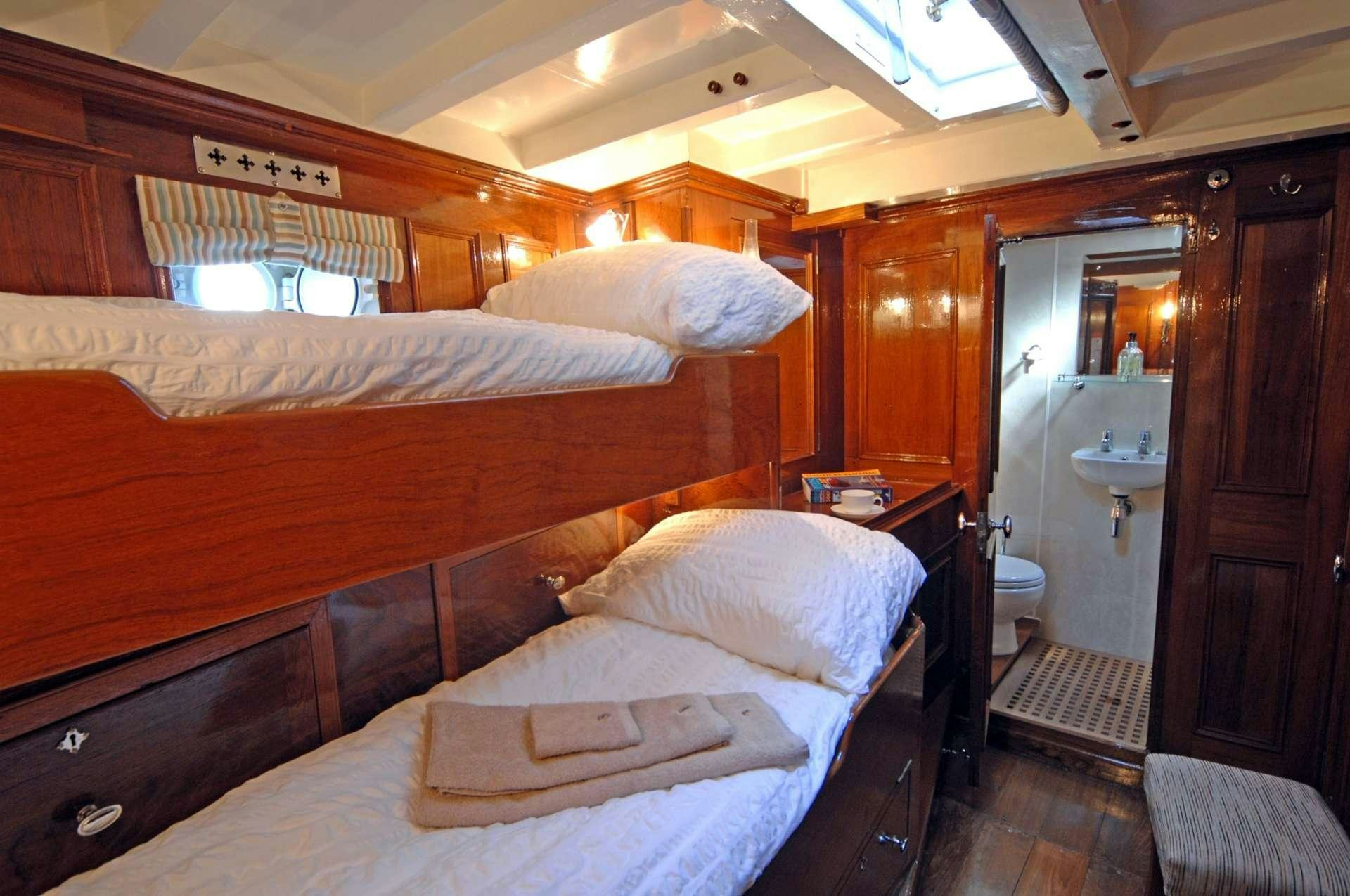a bedroom with a bed and a sink aboard Halcyon Yacht for Charter
