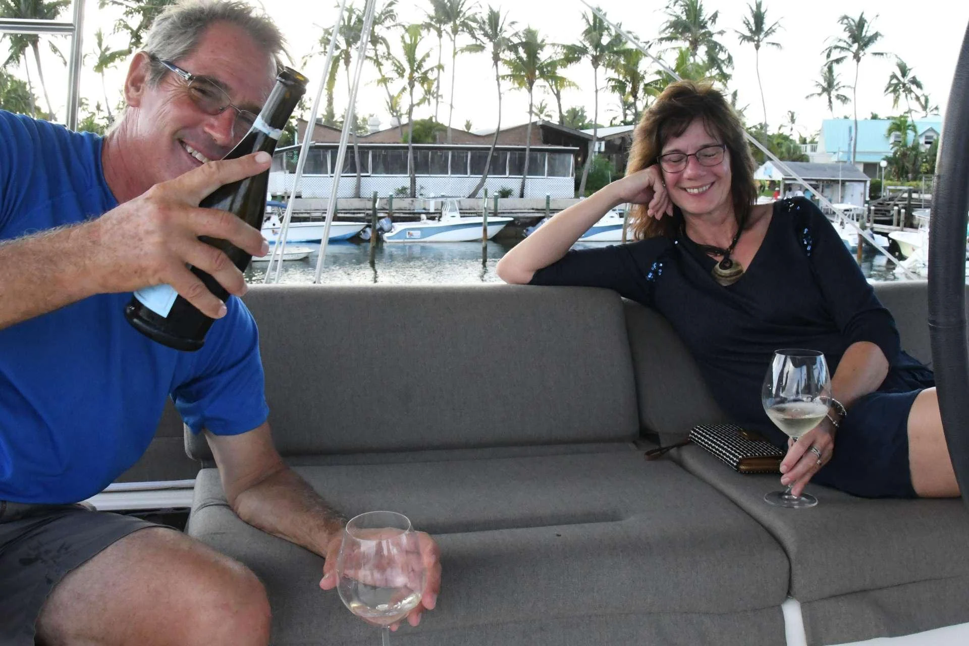 a man and a woman sitting on a couch drinking wine aboard Samoru ll Yacht for Charter