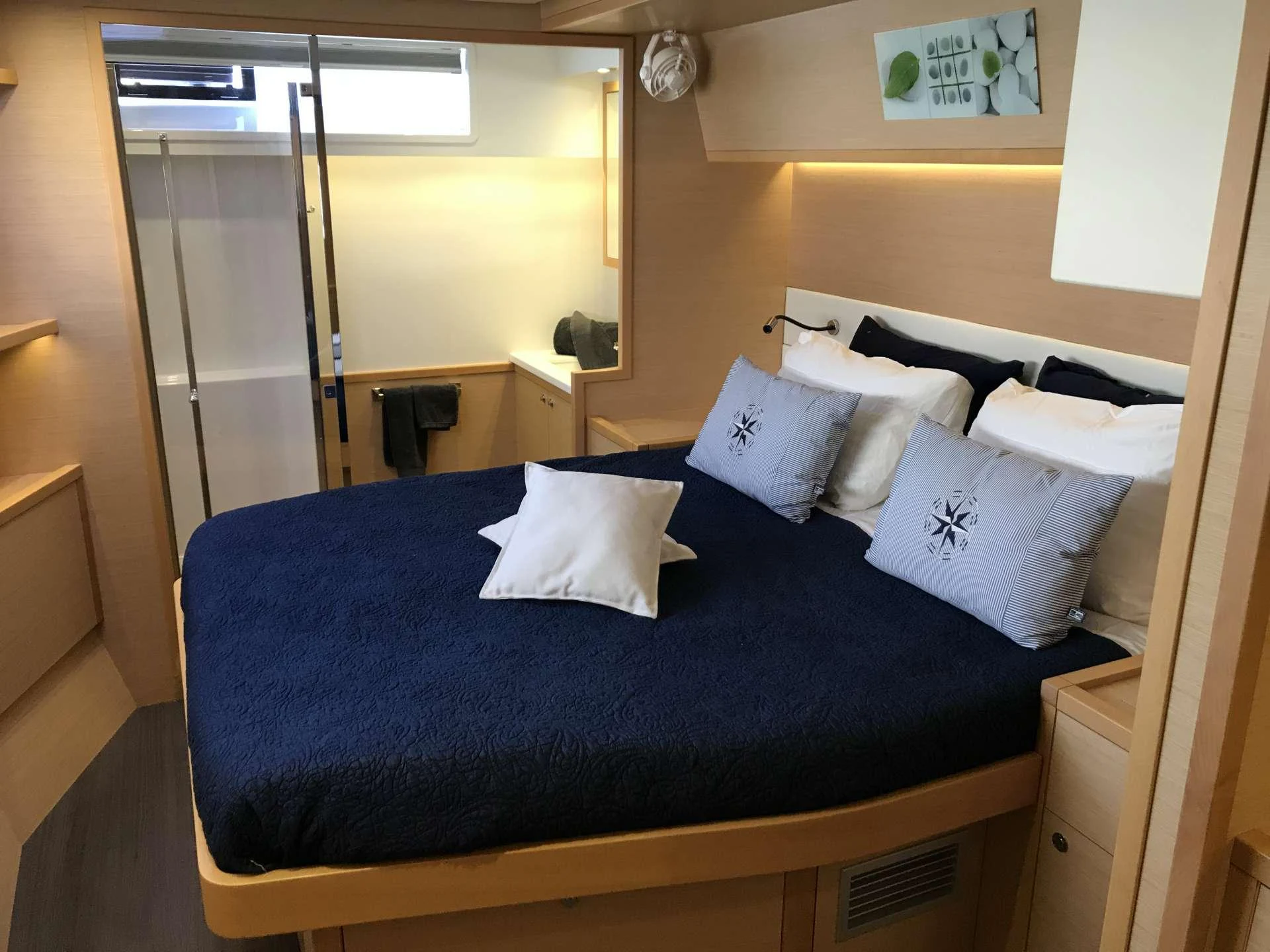 a bed with blue sheets aboard Samoru ll Yacht for Charter