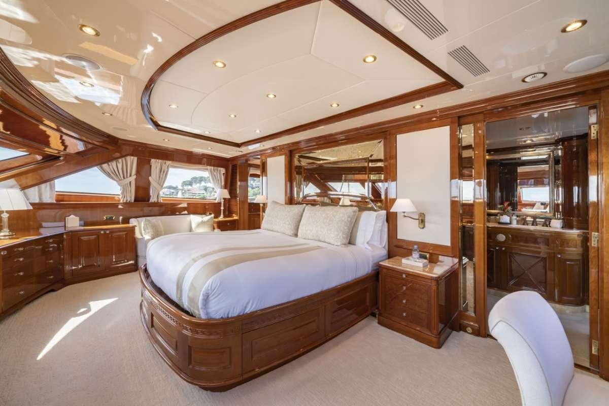 a bedroom with a bed and a mirror aboard AURA Yacht for Charter