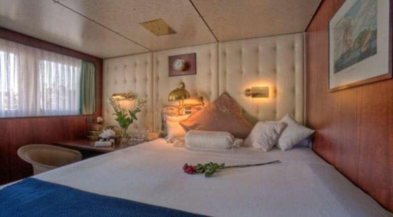 a bed with white sheets and pillows aboard SANSSOUCI STAR Yacht for Charter