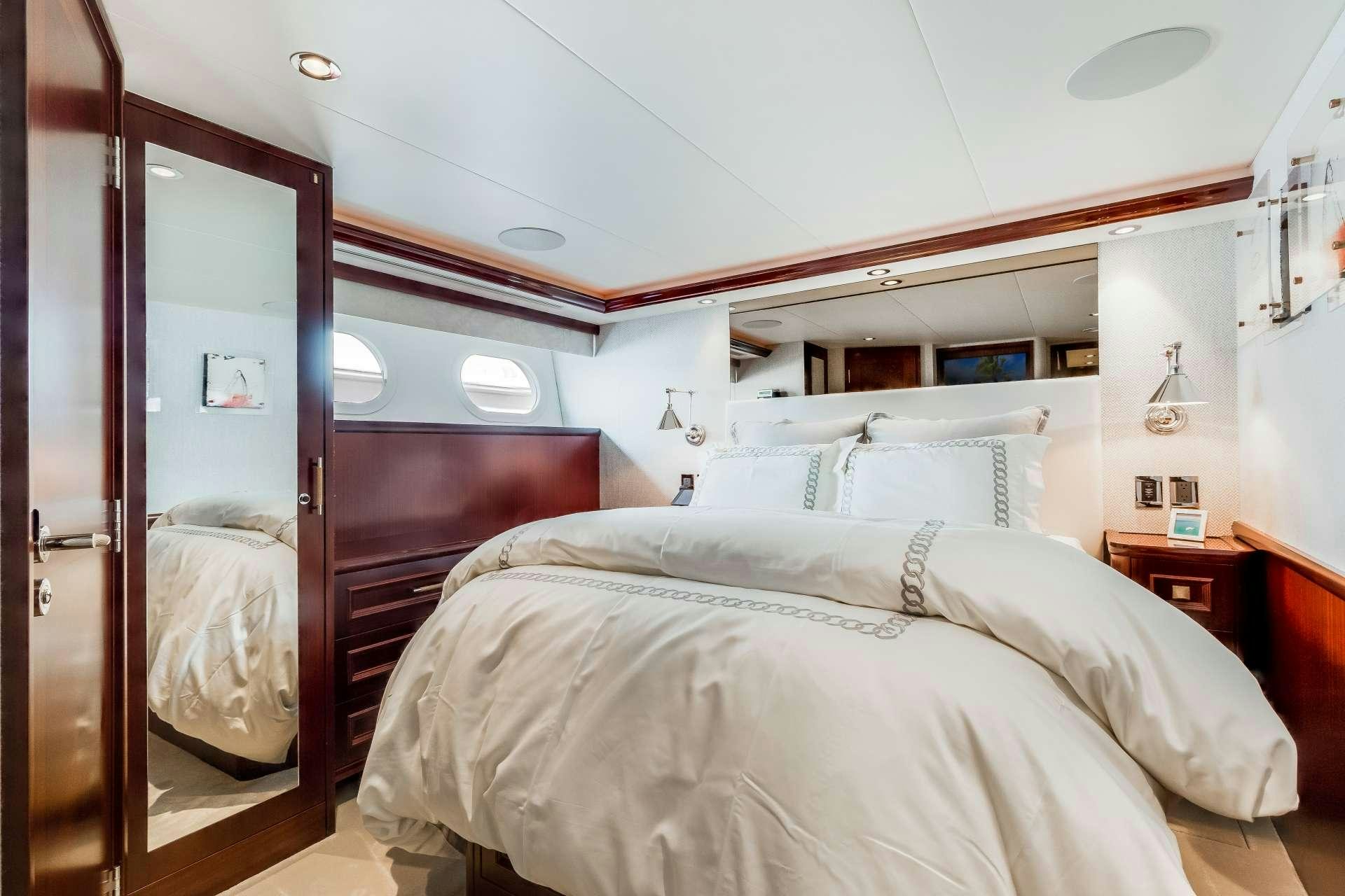 a bedroom with a bed and a mirror aboard OUR HERITAGE Yacht for Charter