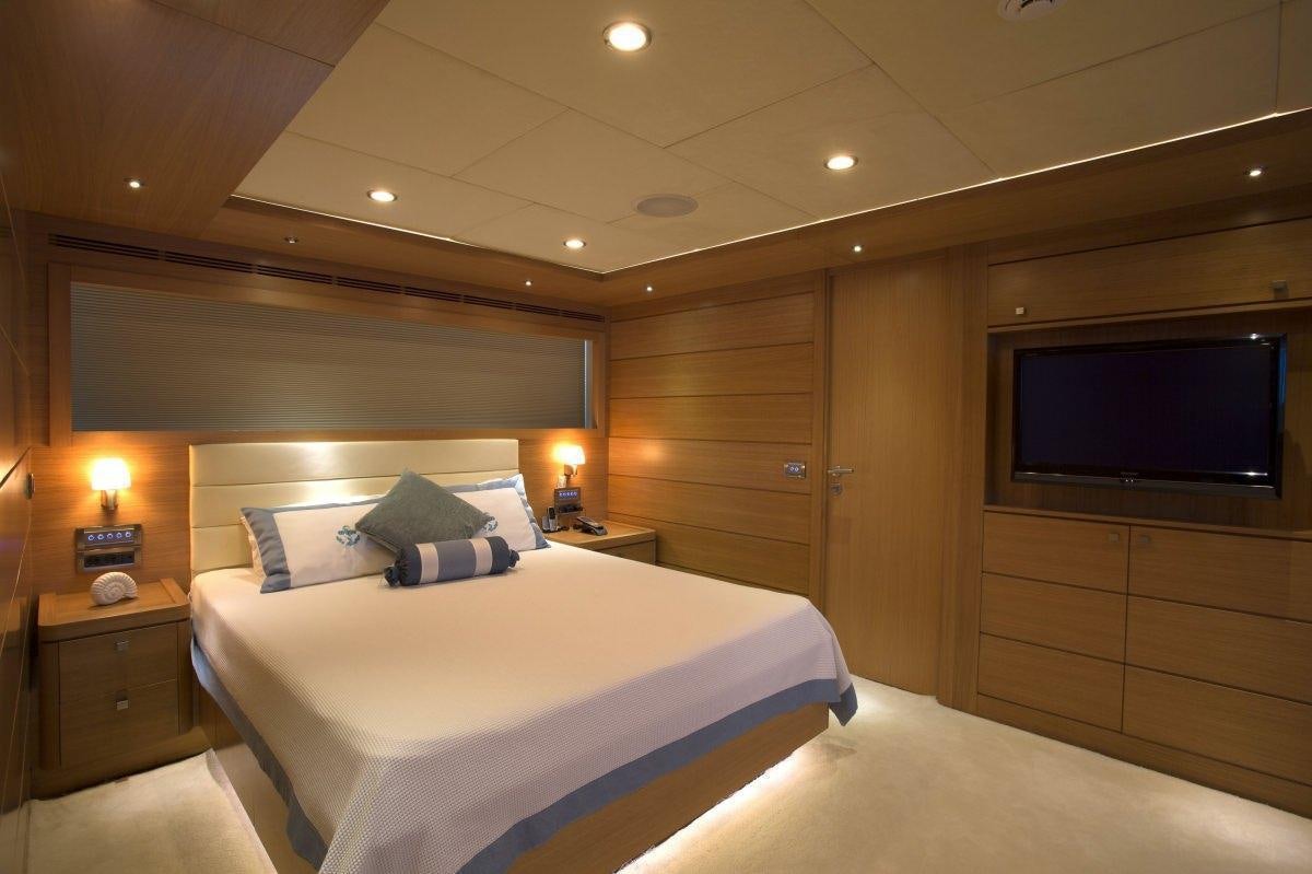 a hotel room with a bed and tv aboard PANFELISS Yacht for Charter