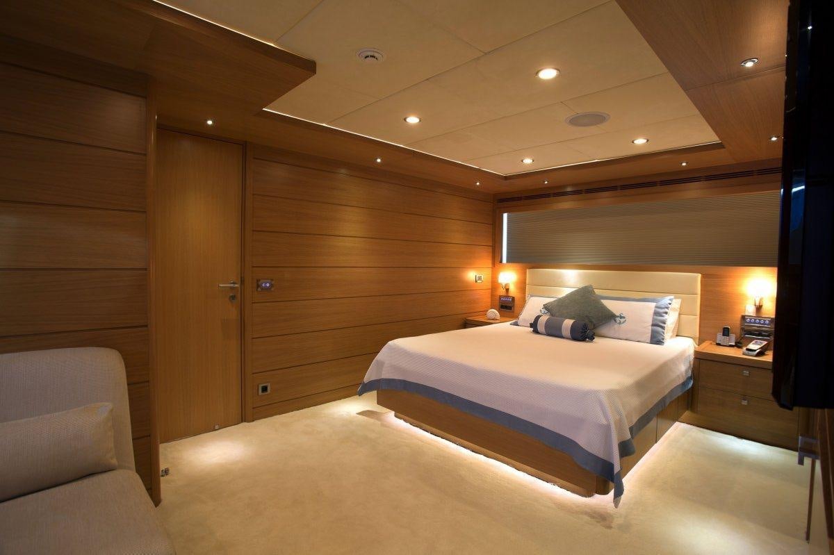 a room with a bed and a chair aboard PANFELISS Yacht for Charter