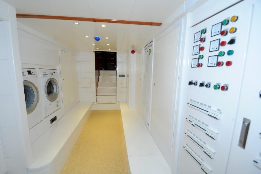 a hallway with white cabinets and a washing machine aboard GULMARIA Yacht for Charter