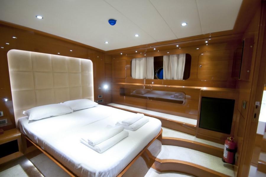 a room with a bed and a television aboard GULMARIA Yacht for Charter