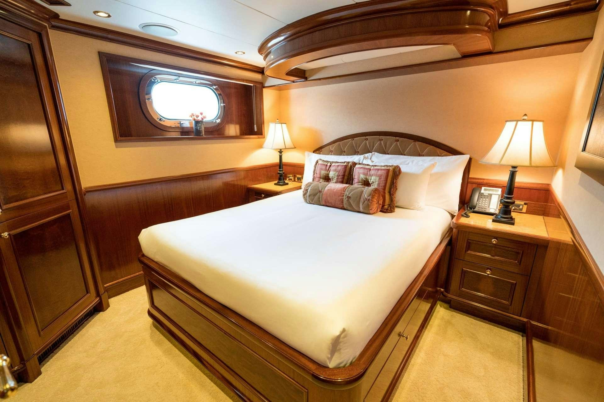 a bedroom with a bed and a television aboard EXCELLENCE Yacht for Charter