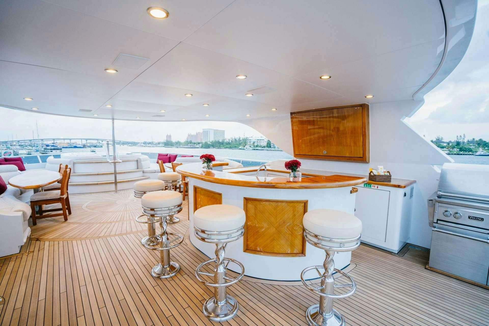 a kitchen with white cabinets and a table with chairs aboard EXCELLENCE Yacht for Charter